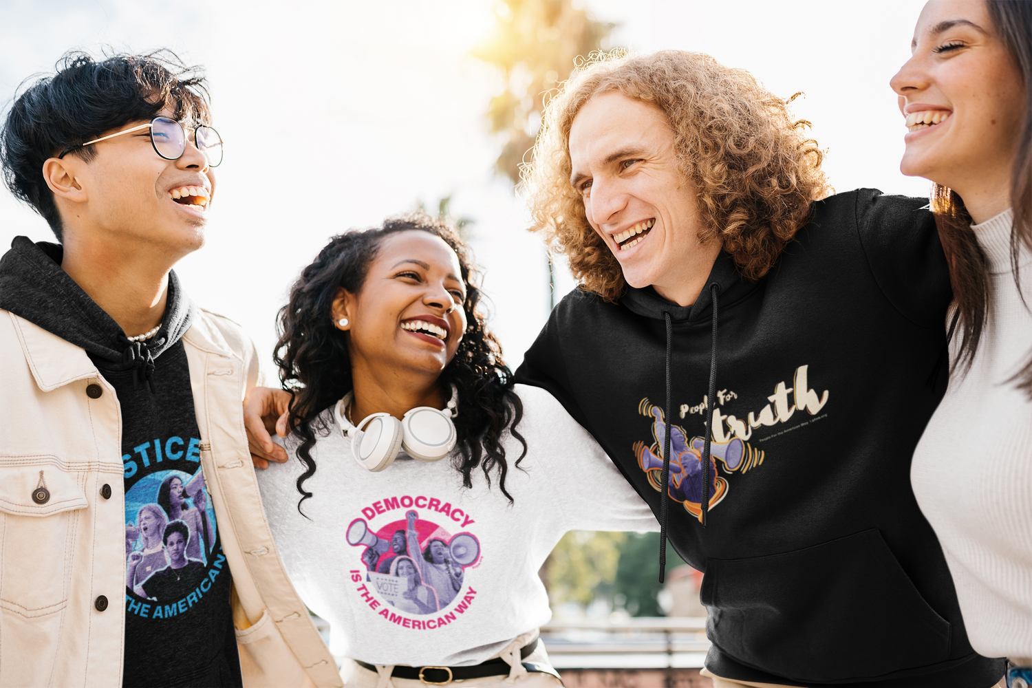 Group of four friends wearing black and white sweatshirts with blue, red, and yellow designs on them.